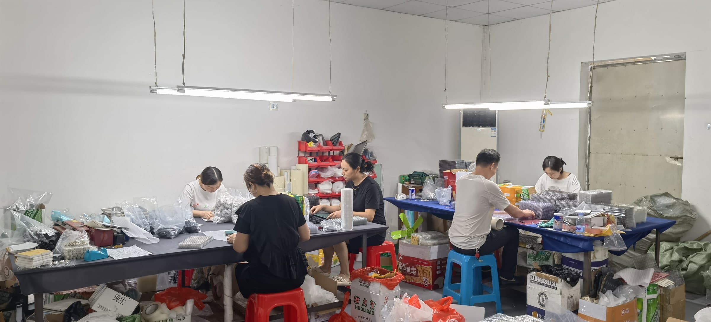 Hongfeng team handling and packing metal hardware at a workstation