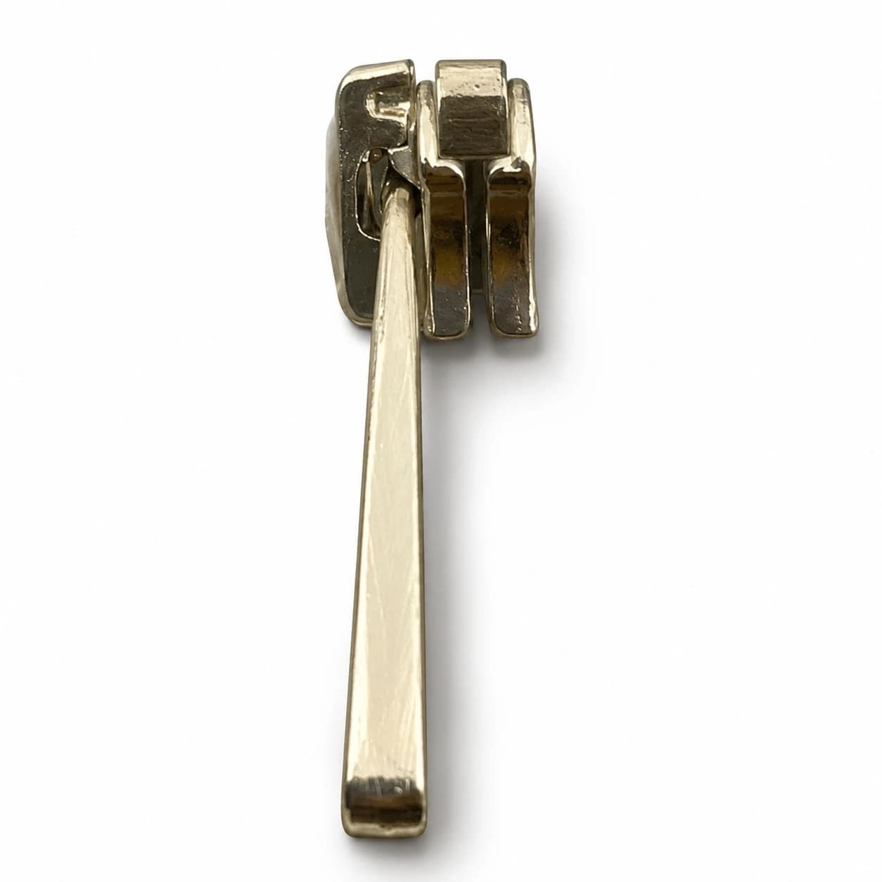 The back of a metal zipper puller showing its connector pin